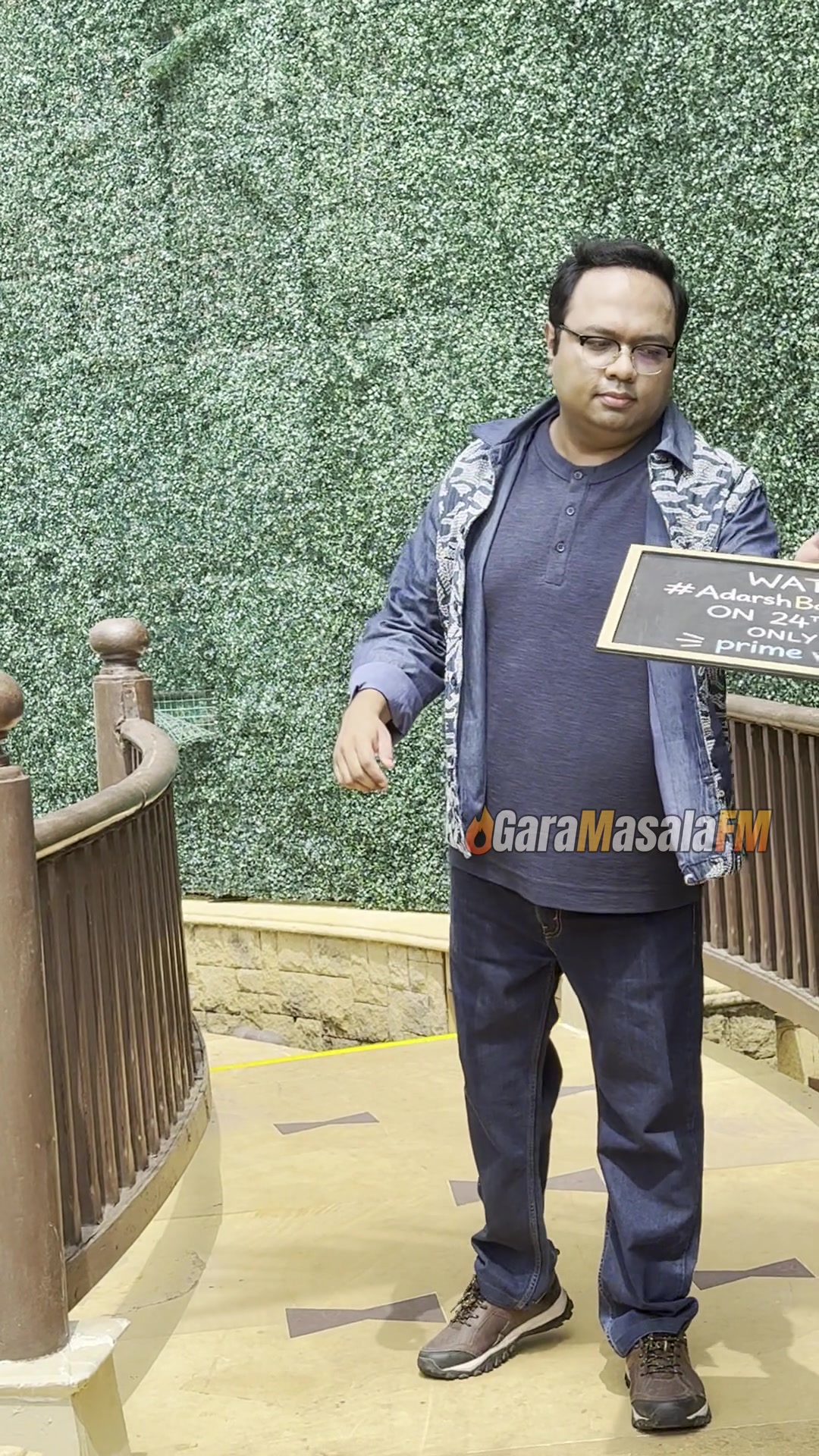Biswapati Sarkar holding the Adarsh Baal Vidyalaya promo board, still from the new video
