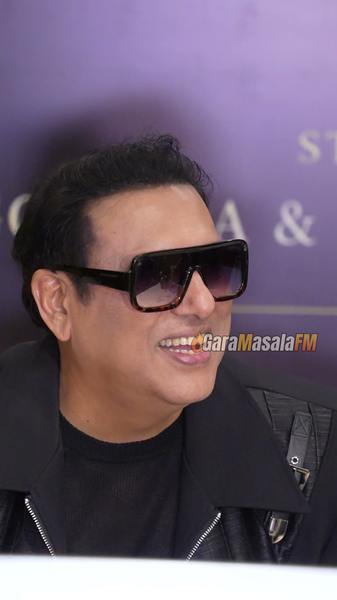 Govinda in an all-black leather jacket and sunglasses at an event